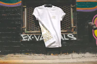 a white t - shirt leaning against a brick wall